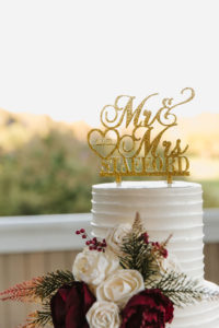 wedding cake with red and whtie flowers and Mr & Mrs Gold Topper