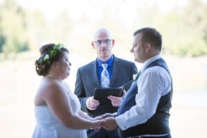 Bride and Groom holding hands in front of officiant